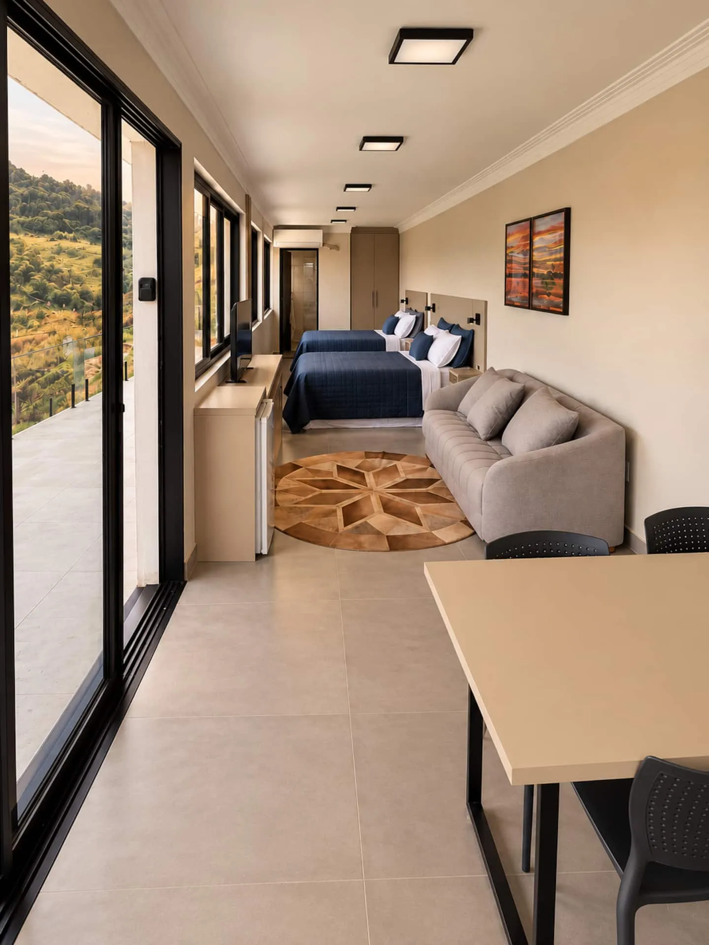 Estúdio do piso inferior: sala e quarto integrados, com portas de correr para a varanda