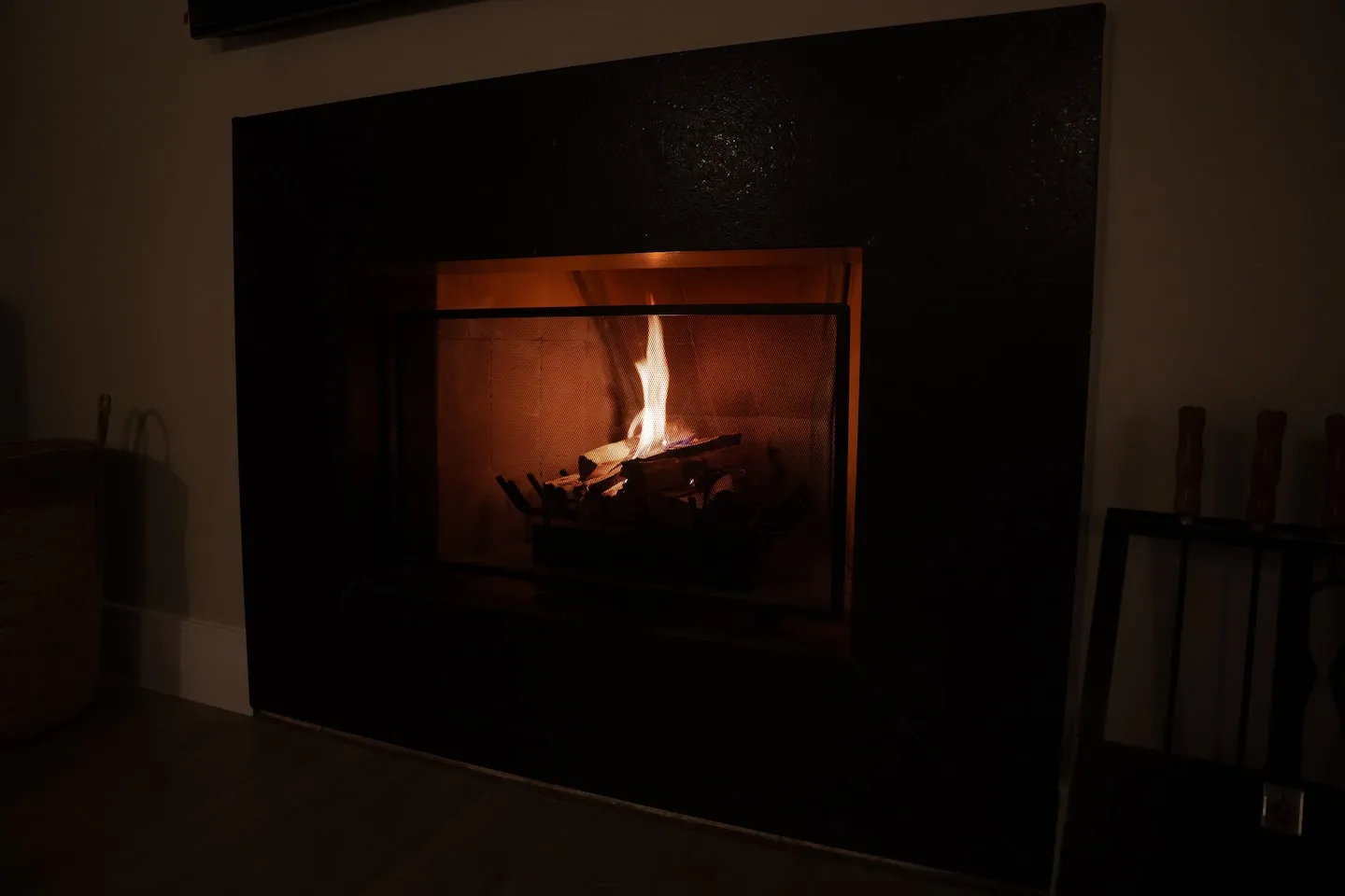 Lareira com fogo aceso em painel escuro