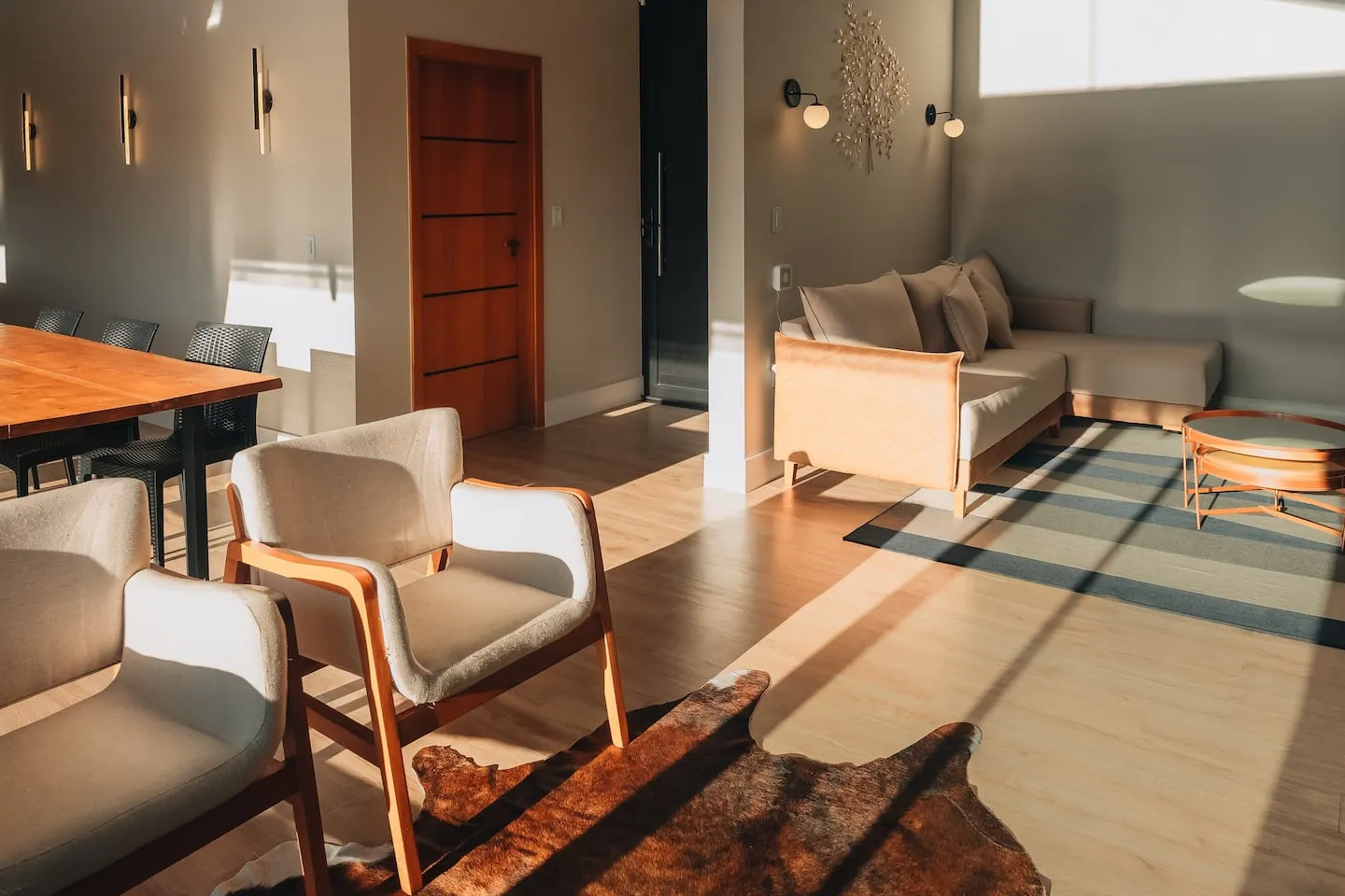 Sala de estar e jantar integradas, com poltronas e tapete
