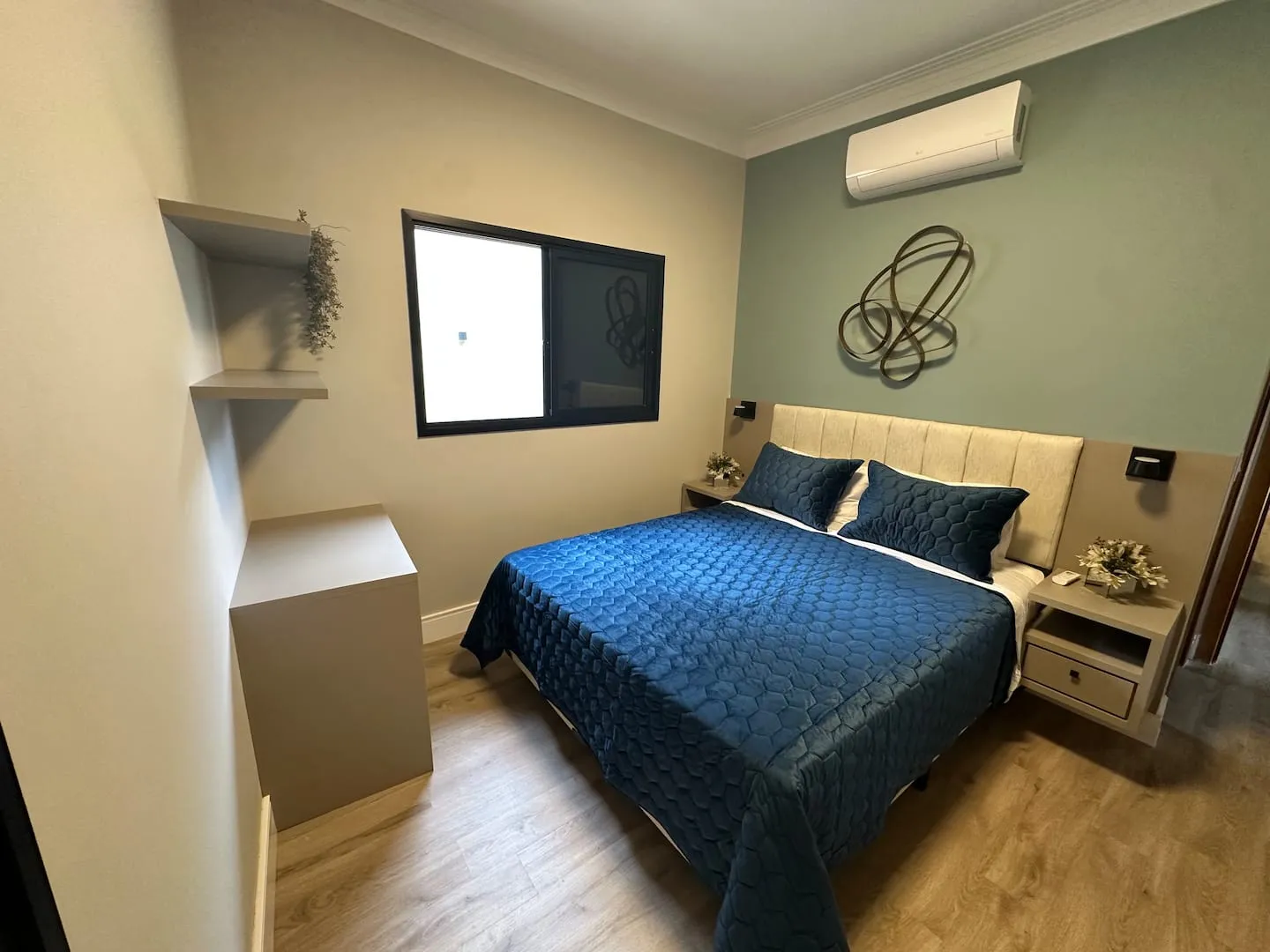 Suíte 2 com cama queen, parede verde-acinzentada e ar-condicionado