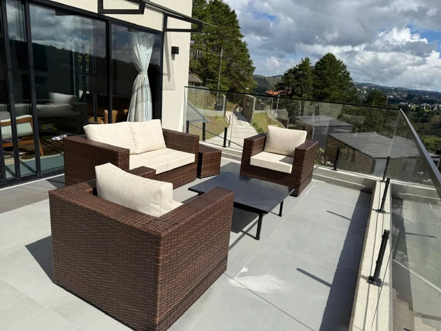Poltronas da varanda sob o céu de nuvens, com a paisagem ao fundo