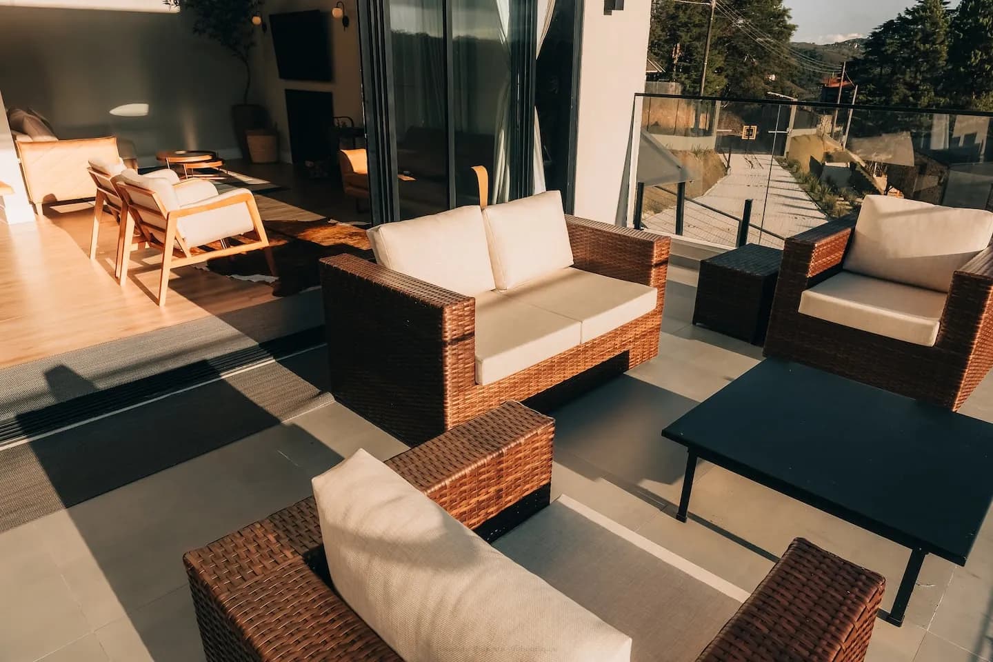Sofás de vime na varanda, com a sala ao fundo