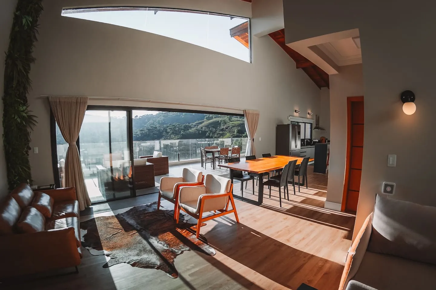 Sala e sala de jantar com janelas panorâmicas e pé-direito alto