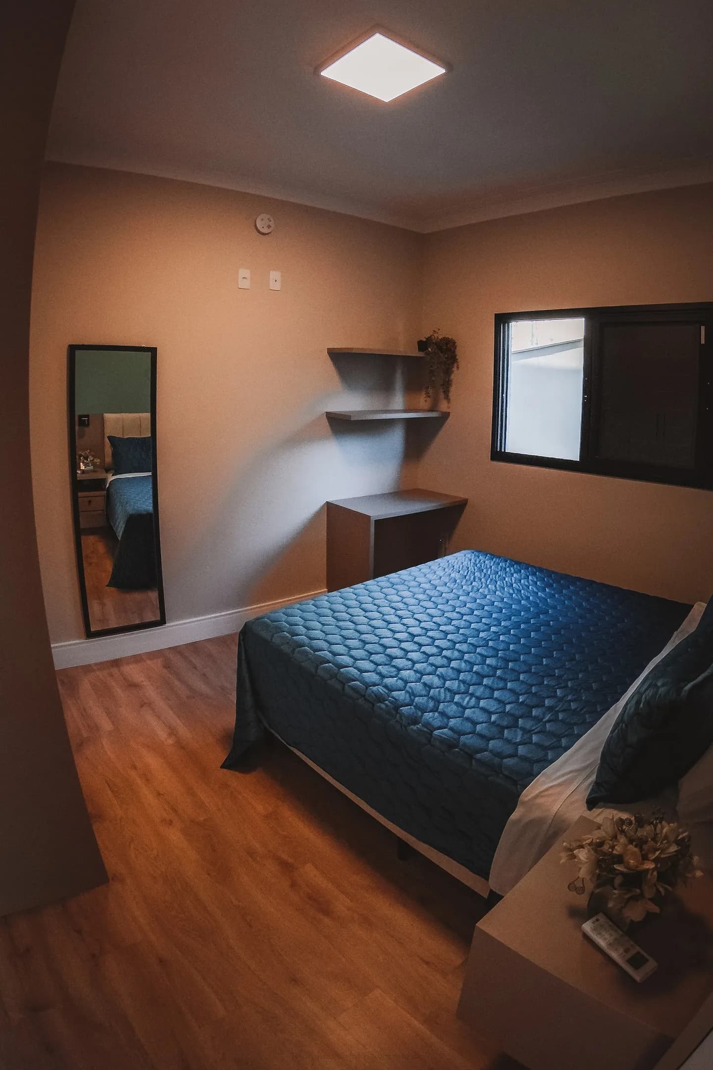 Suíte com cama queen e luz quente da janela