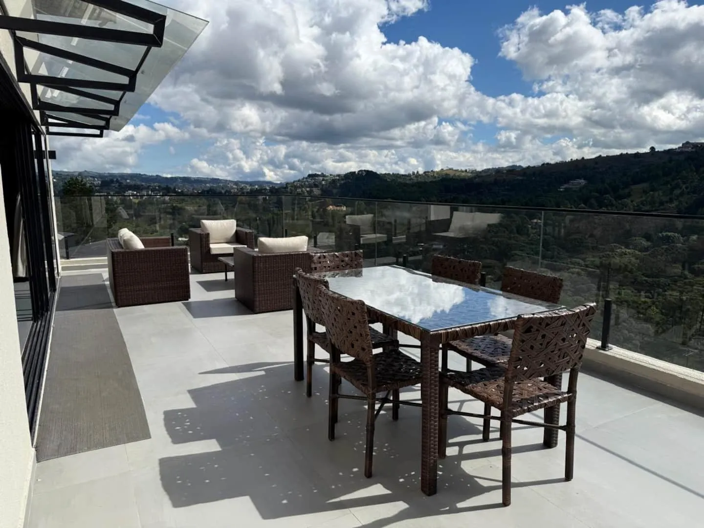 Varanda com mesa de jantar e vista aberta para as montanhas